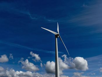 Low angle view of windmill against blue sky