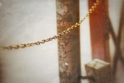 Close-up of chain against window