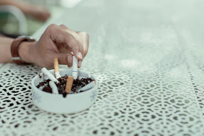 Close-up of hand holding cigarette