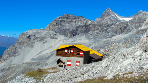 Built structure on rocky mountain against sky