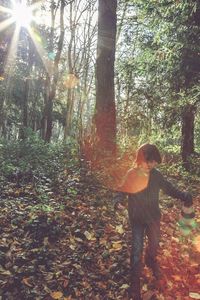 Rear view of woman standing by tree