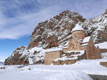 Built structure on snowcapped mountain against sky