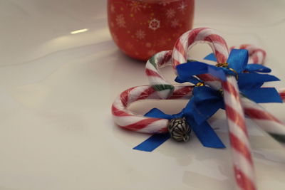 Close-up of candy canes with blue ribbons on table