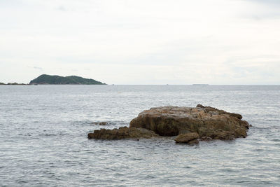 Rock formation in sea against sky