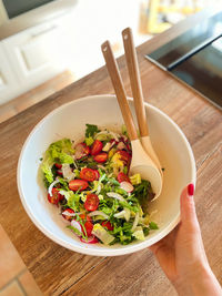 High angle view of hand holding salad in bowl