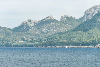 Scenic view of sea and mountains against sky