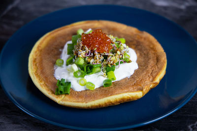 Close-up of a pancake with caviar on table