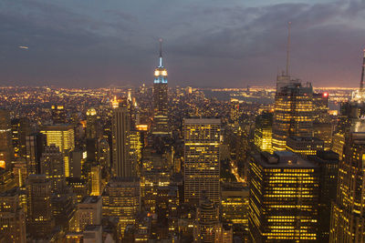 Illuminated modern buildings in city against sky