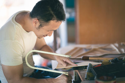Side view of man working on table