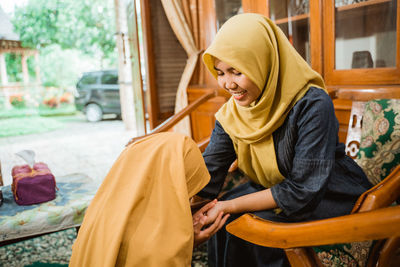 Daughter giving respect to mother at home