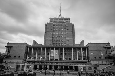 Low angle view of buildings against cloudy sky