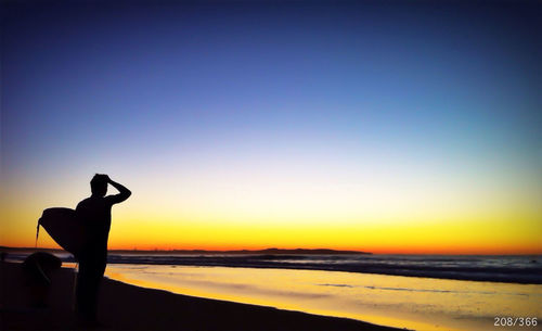 Silhouette of people on beach at sunset