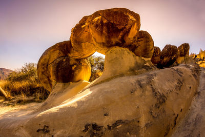 Rock formation on rocks against sky during sunset