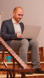 Man using laptop while sitting on sofa