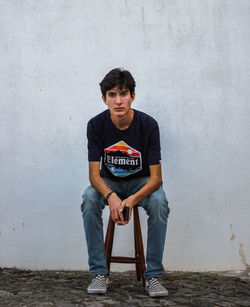 Portrait of young man against wall