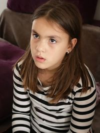 Thoughtful girl sitting at home