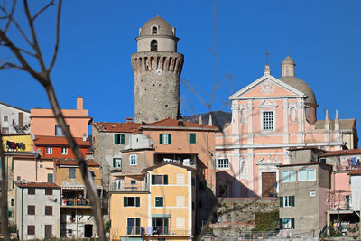 Buildings in town against clear blue sky