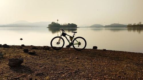 Bicycles on lake against sky