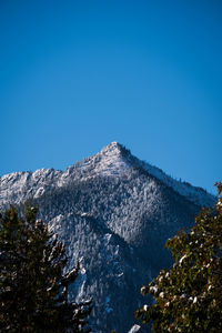 Scenic view of snowcapped mountains against clear blue sky