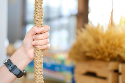 Cropped image of hand holding rope