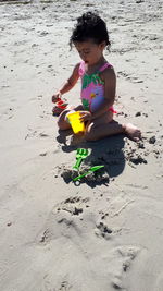 High angle view of girl playing on sand at beach