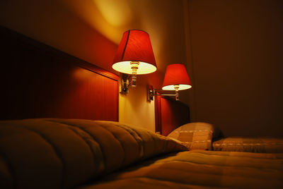 Illuminated electric lamp on bed at home