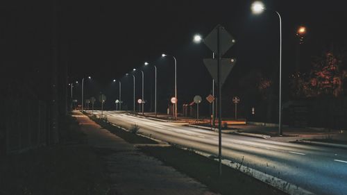 Illuminated street light on road at night