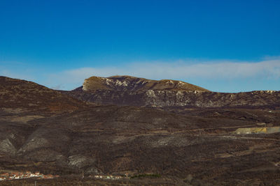 Scenic view of mountains against blue sky