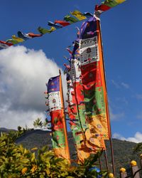 Low angle view of flags hanging against sky