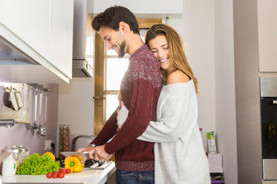 Young couple standing in front of people at home