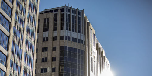 Low angle view of modern building against clear blue sky