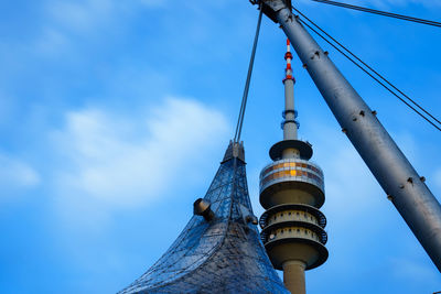 Low angle view of communications tower against cloudy sky