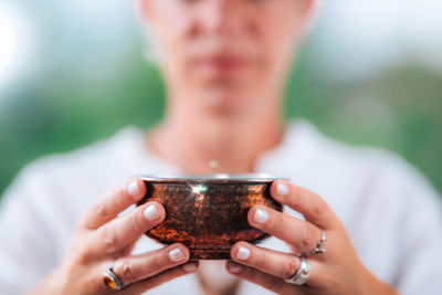 High-minded person holding an energized copper bowl, boosting a positive feeling 