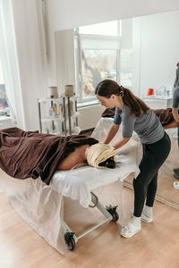Masseuse doing anti stress body massage on young woman