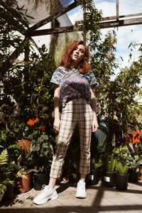 Portrait of smiling woman standing against trees