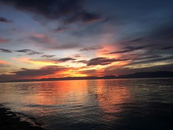 Scenic view of sea against dramatic sky during sunset