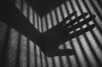 Shadow of hand on tiled floor