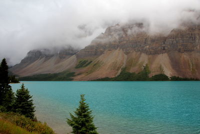 Scenic view of lake by mountains against sky