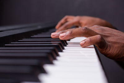 Cropped hand of woman playing piano