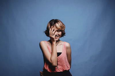 Woman standing against blue wall