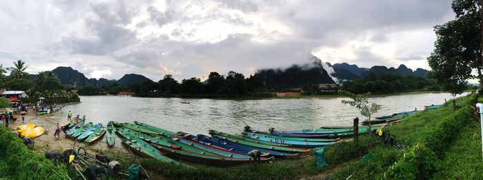 Panoramic view of boats moored in river against sky