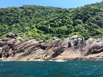 Scenic view of rocks in sea against sky