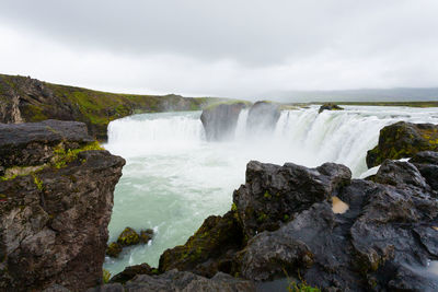 Scenic view of waterfall against sky