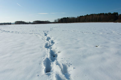 Scenic view of snow covered field against sky