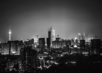 Illuminated cityscape against sky at night 