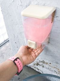 Cropped hand of woman under soap dispenser