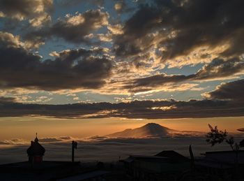 Silhouette people standing on mountain against sky during sunset