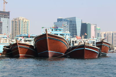 Boats moored in sea against clear sky