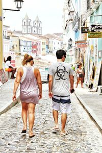 Rear view of people walking on street in city