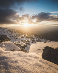 Scenic view of snow covered land against sky during sunset